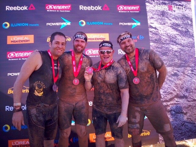 Foto posando con las medallas con Joaquín, David Casinos y Ángel Sanz, organizador y guía de David, todos llenos de barro