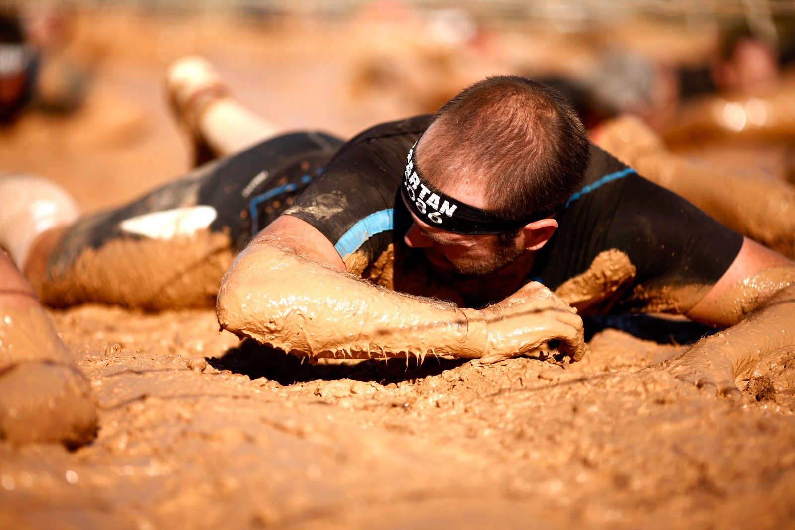 Cruzando la pista americana en la Spartan 2015, arrastrándme por el barro bajo los alambres de espino